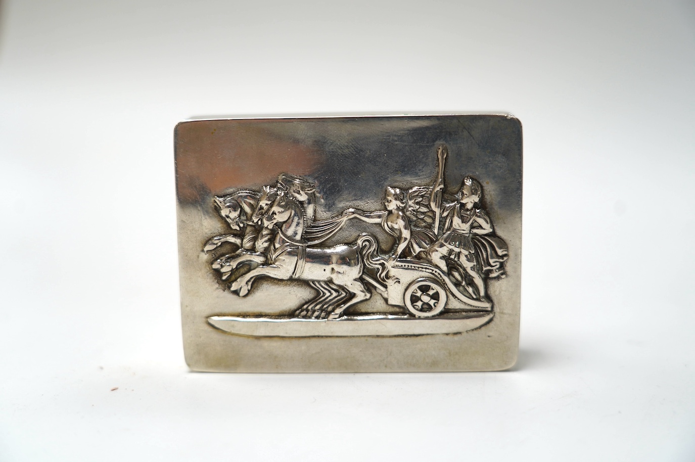 A German 800 standard white metal snuff box, the cover embossed with chariot scene, 78mm. Condition - fair to good